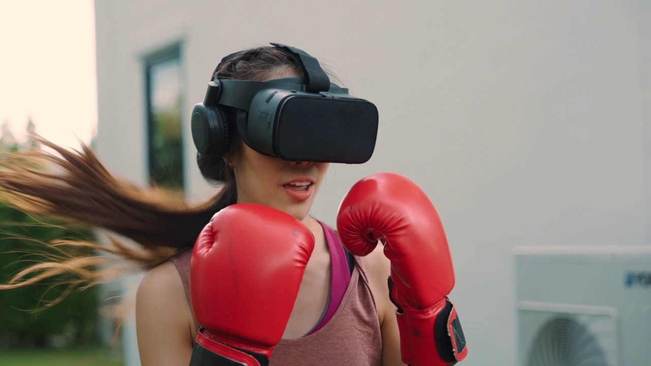 亚洲女性戴着虚拟现实头盔玩拳击运动视频素材