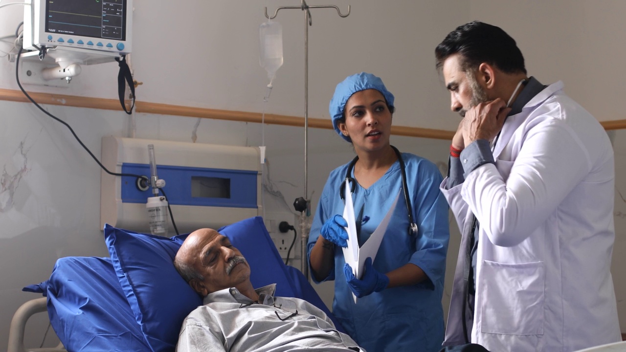 医生和护士一起检查躺在病床上的病人视频素材