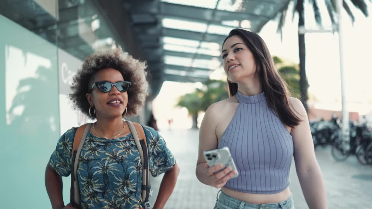 两个快乐的多民族女人边走边聊视频素材