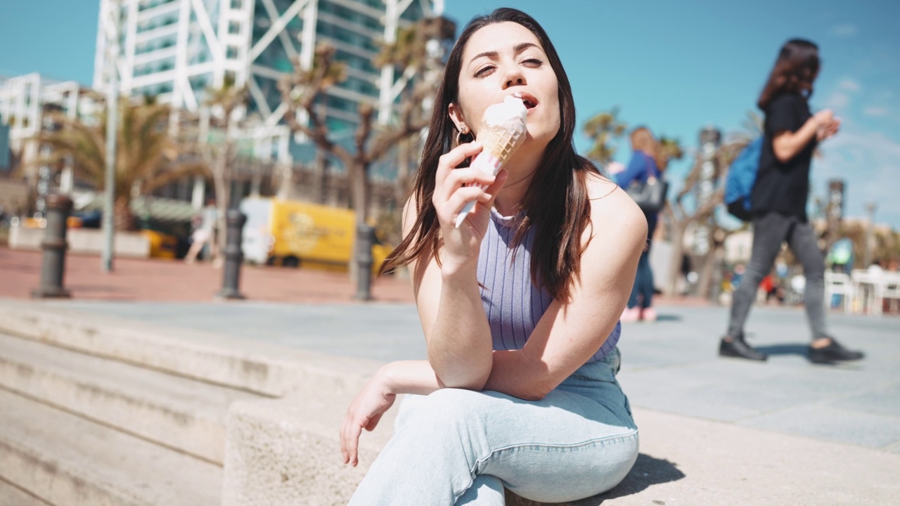 微笑着吃冰淇淋的黑发女人视频素材
