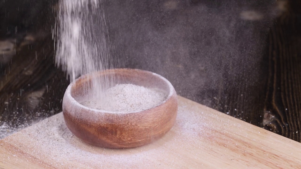 将加麦麸的小麦粉倒入一个木盘视频素材