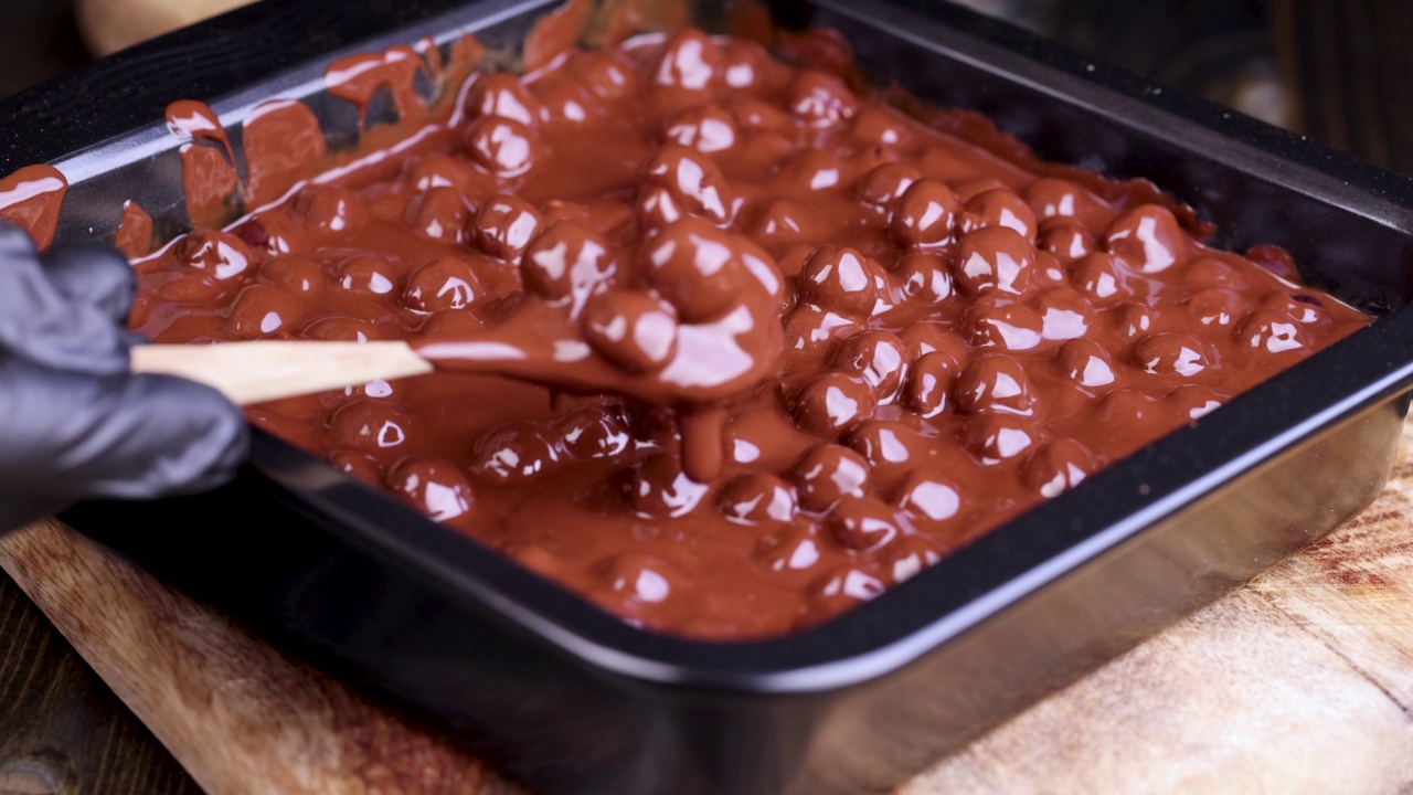 在融化的液体巧克力中加入烤榛子视频素材