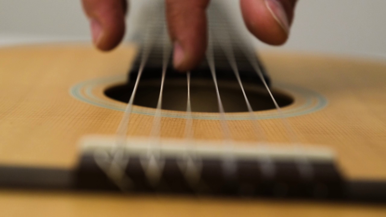 特写的男性音乐家和演奏吉他的弦视频下载