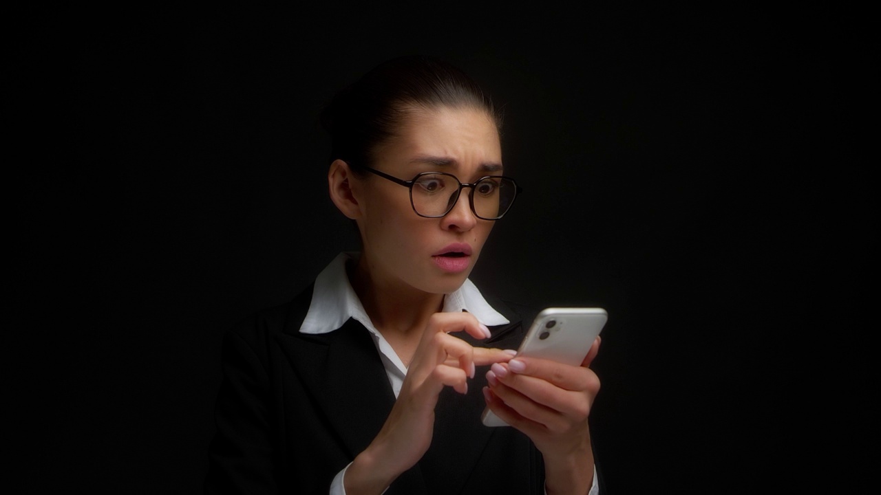 女商人惊恐地读着智能手机上的一条信息视频素材