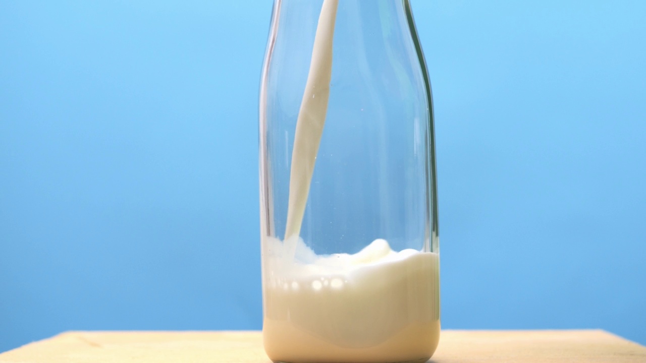 把新鲜牛奶倒进瓶子里。视频下载