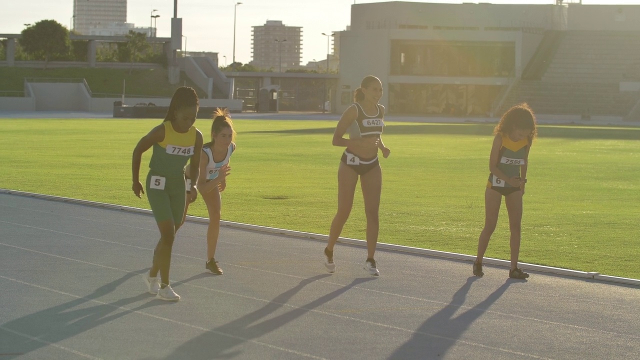 女子田径短跑运动员在阳光明媚的跑道上比赛视频下载