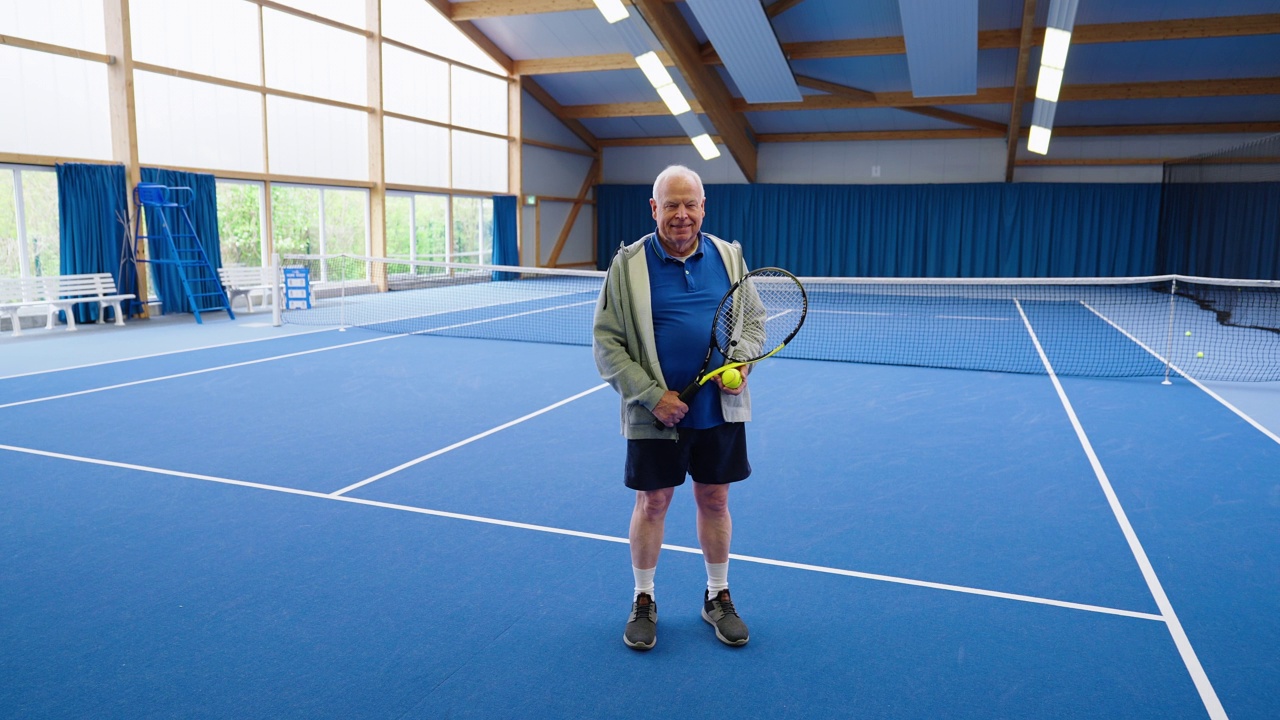 一个自信的年长男子站在网球场上的肖像视频素材