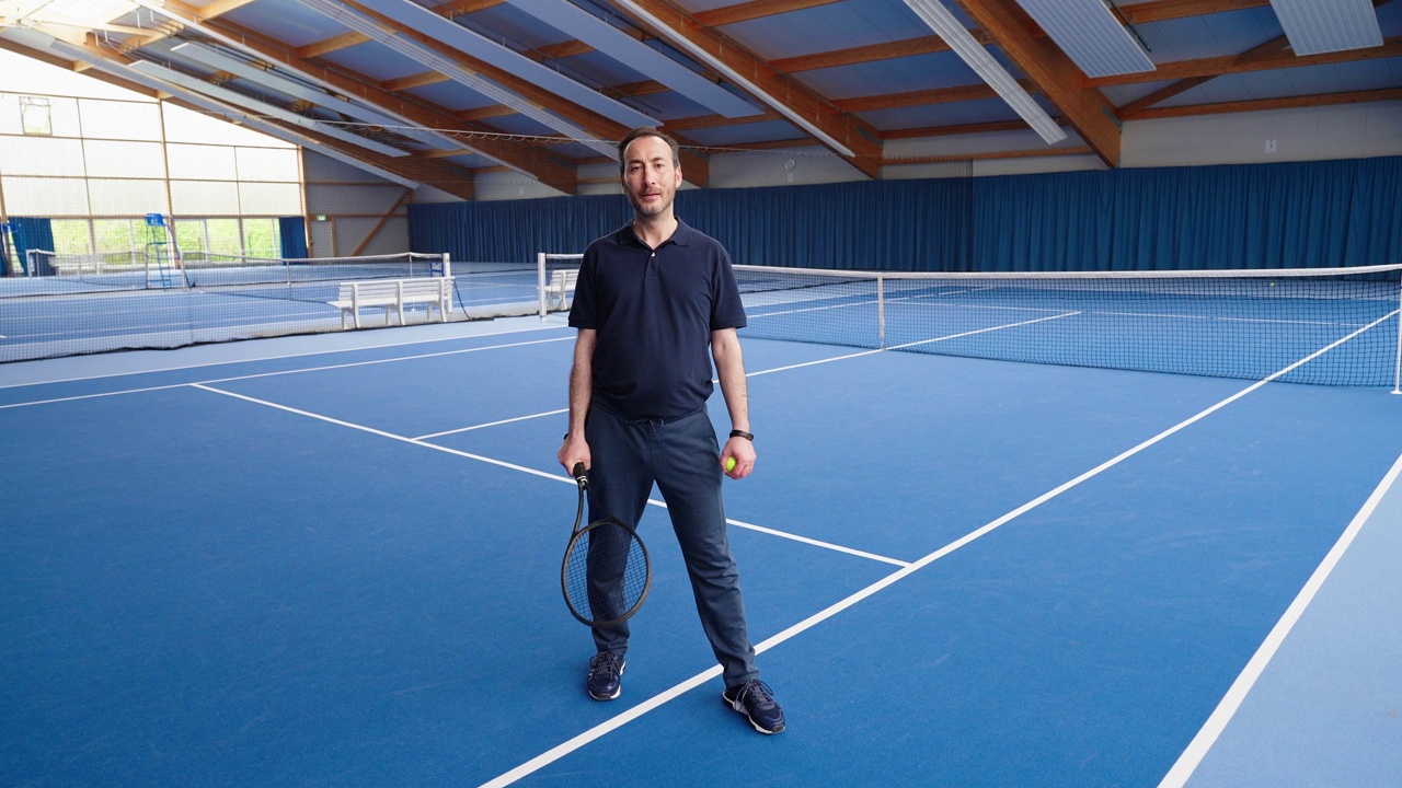 一个快乐的成熟男子网球运动员在室内球场的肖像视频素材