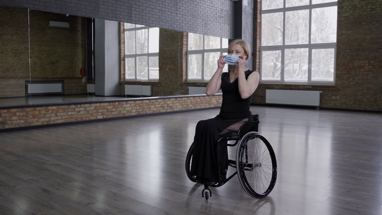 坐在轮椅上的舞女在室内戴着面具视频下载