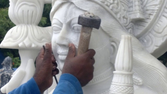 印度工匠雕刻传统印度教女神拉克希米或拉克希米白色大理石雕塑或雕像出售，使用锤子和凿子，手移动。视频下载