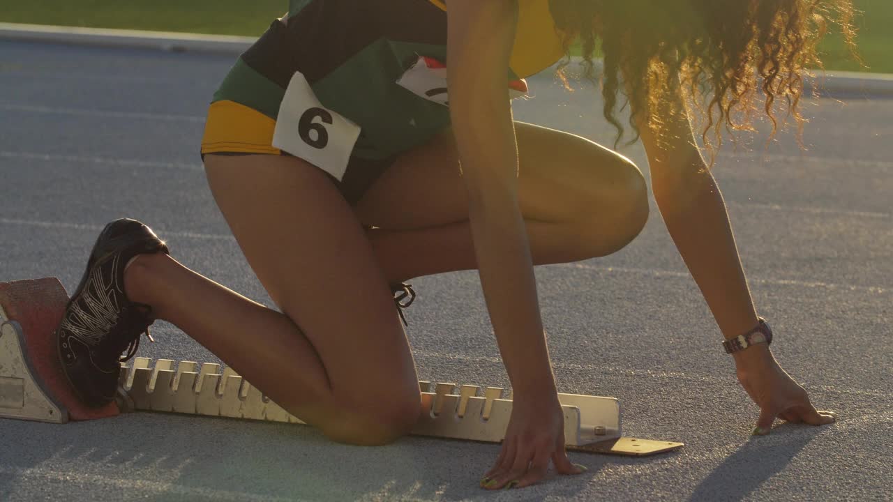 女子田径运动员在跑道上准备起跑视频素材