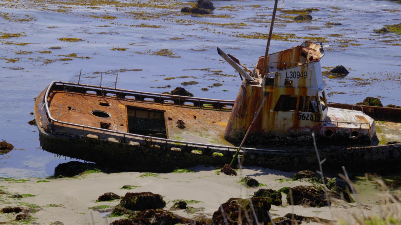退潮时岩石上腐烂的渔船。4 k,没有人。视频素材