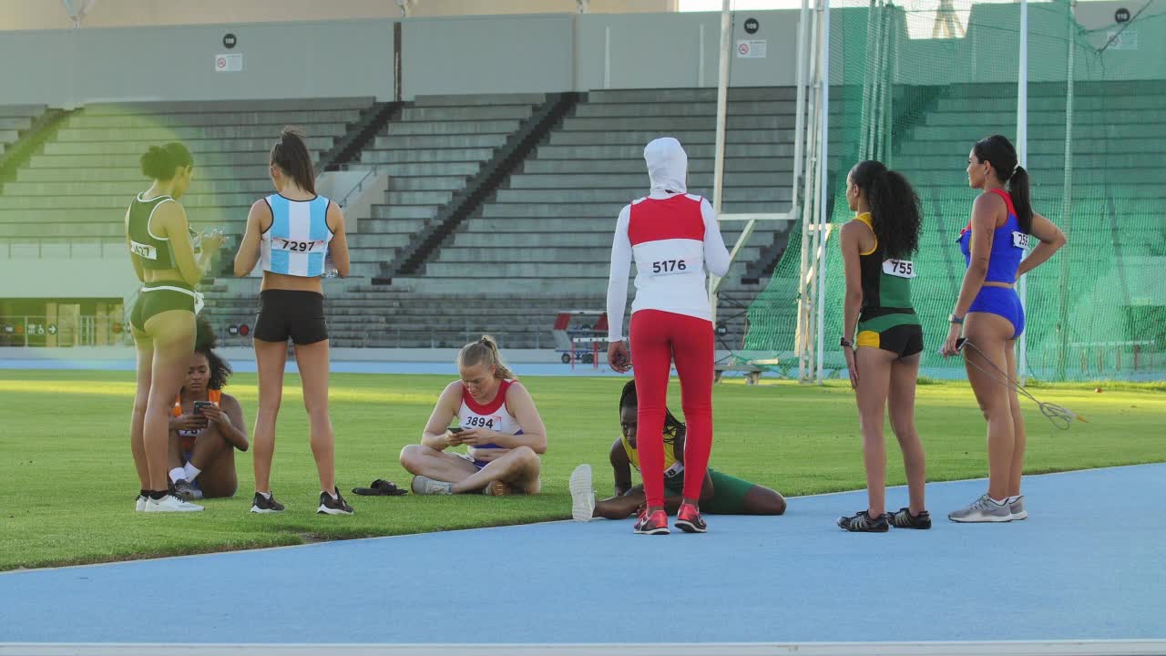 女田径运动员在跑道上休息和交谈视频下载