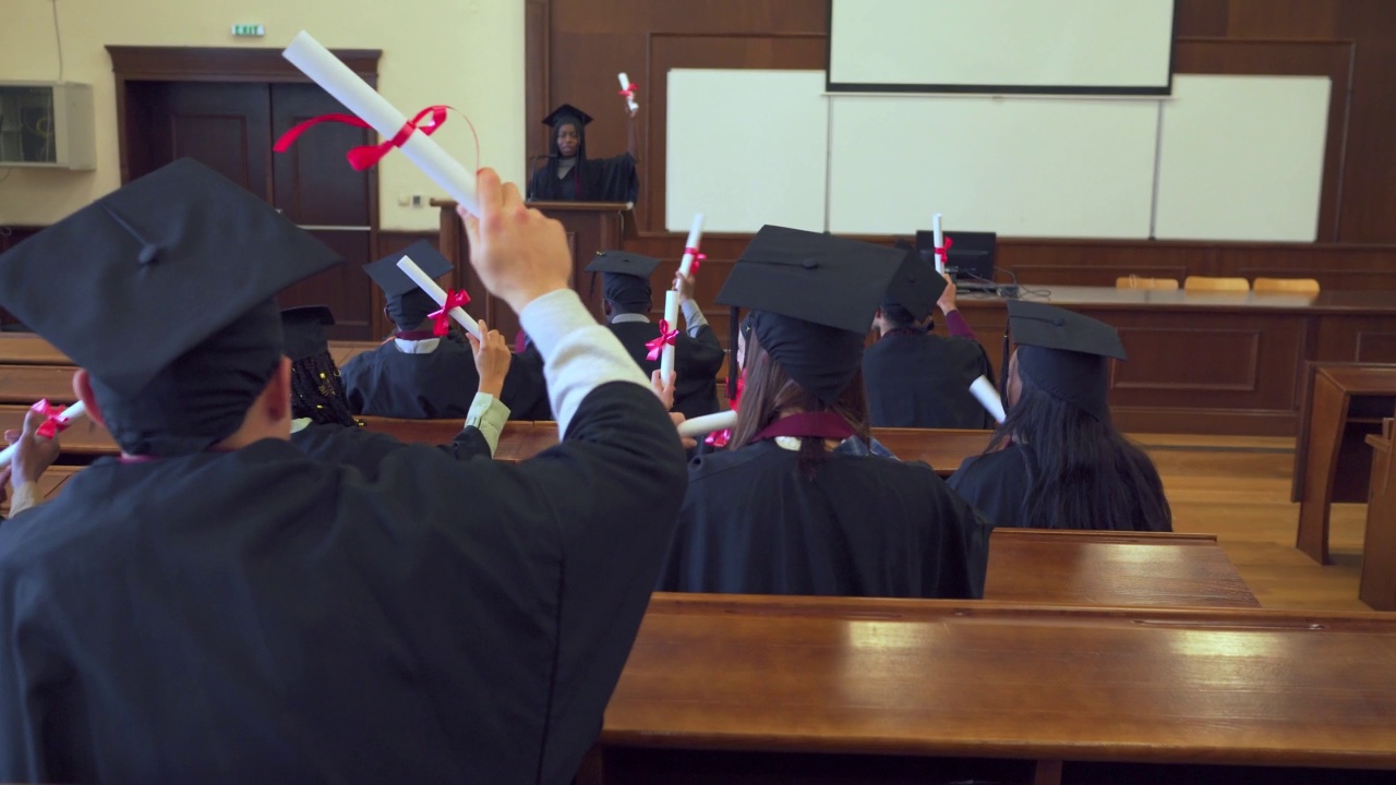 毕业典礼上，毕业生们挥舞着毕业证欢呼雀跃视频素材