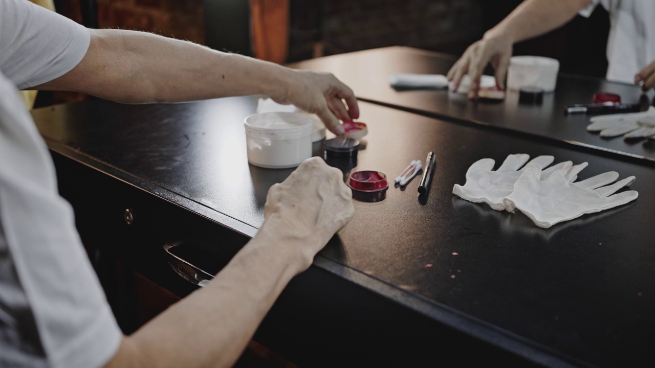 演员打开涂有红色油漆的罐子，准备化妆视频素材