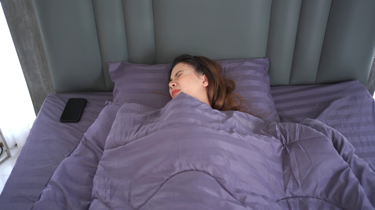 女人用智能手机闹钟睡觉。视频素材