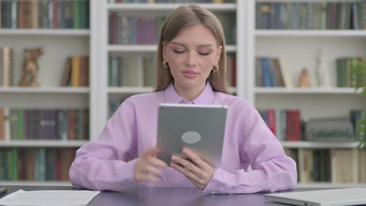 女性在办公室庆祝平板电脑的成功视频素材