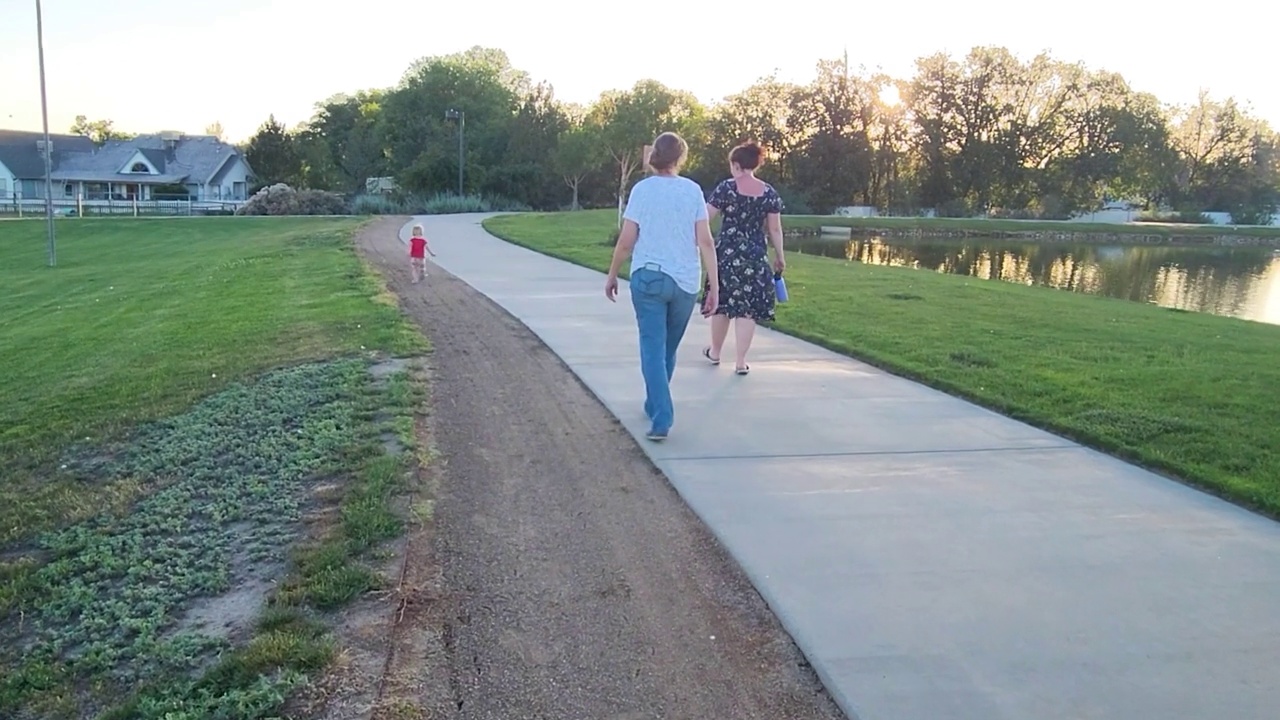 祖母，女儿和孙女走在一条小路上视频下载