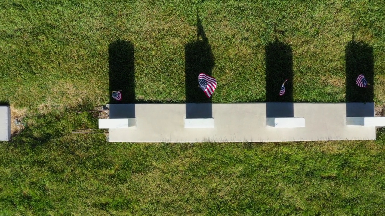 悬挂美国国旗的无人机从墓碑上俯视和上升到墓碑场视频下载