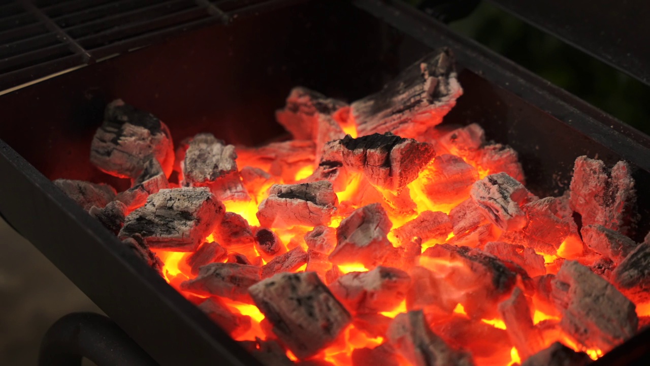 特写镜头的木炭燃烧出火焰在烧烤架。视频素材