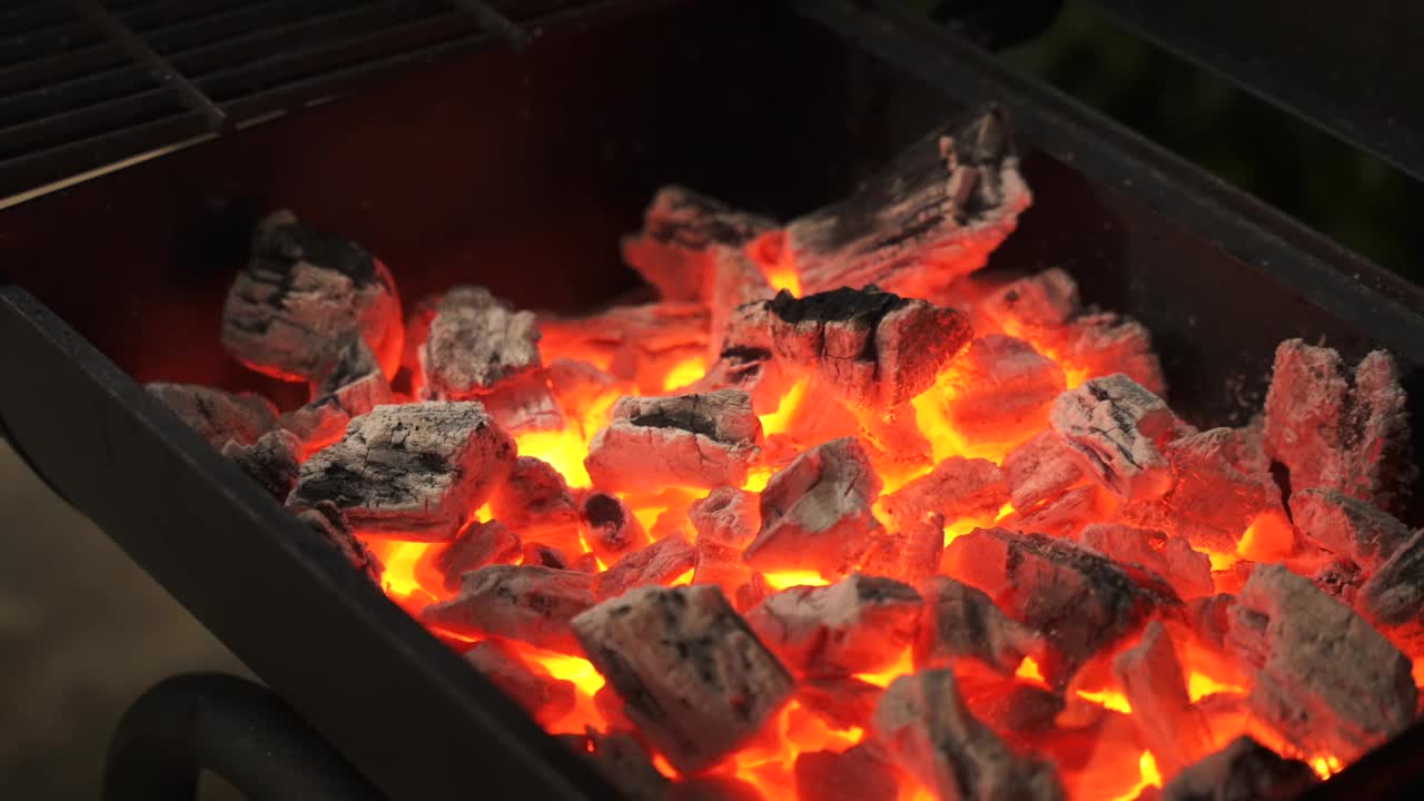 特写镜头的木炭燃烧出火焰在烧烤架。视频素材