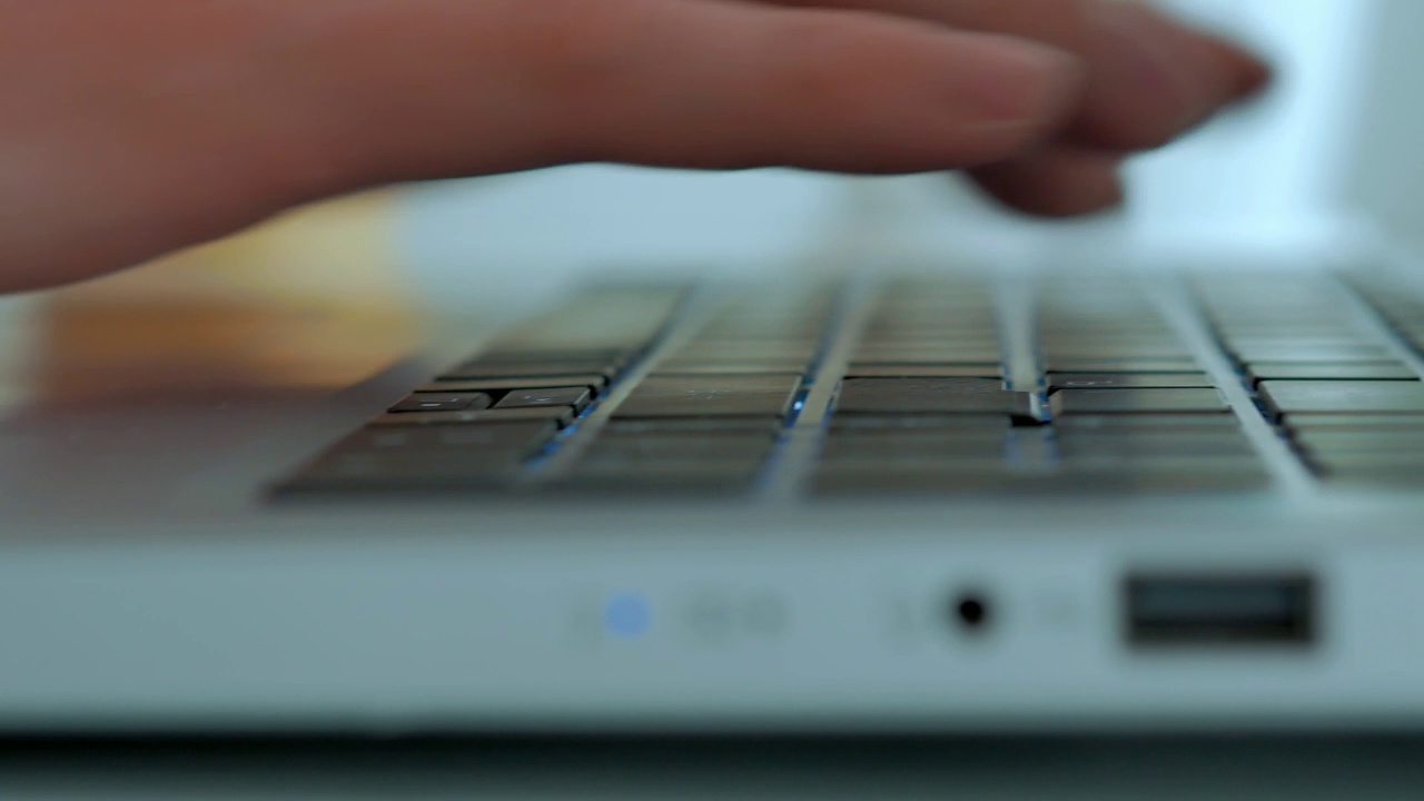 一张特写，男性双手敲击笔记本电脑的键盘，打印一段文字，选择性对焦视频素材