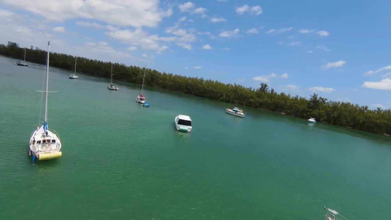 无人机在码头的帆船上空飞行，背景是废弃的迈阿密海军体育场视频素材