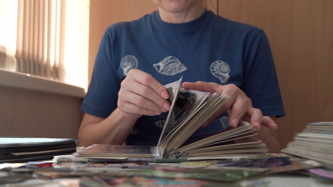 一个陌生女人看着家庭相册里的照片。视频下载