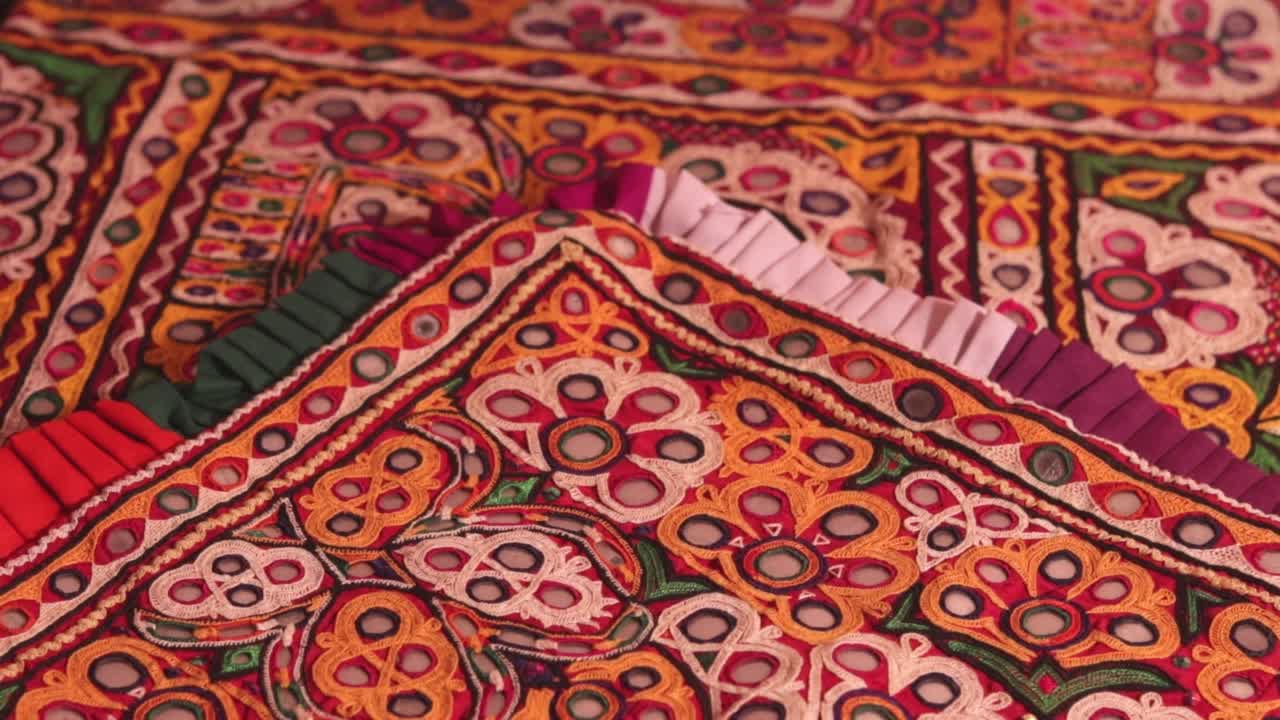镜面刺绣工作典型的阿希尔部落，身份不明的男子刺绣布在印度传统方法，镜面工作彩色手工阿希尔bharat，库奇-古吉拉特邦视频素材