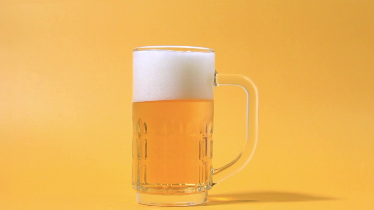 用特写的视角从瓶口往玻璃杯里灌新鲜的啤酒视频素材