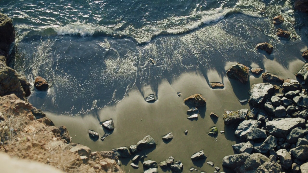 沿着特内里费岛火山岩石海岸线的户外海滩，西班牙，加那利群岛，欧洲。海浪拍打着多岩石的海岸。低潮。缓慢的运动。视频素材