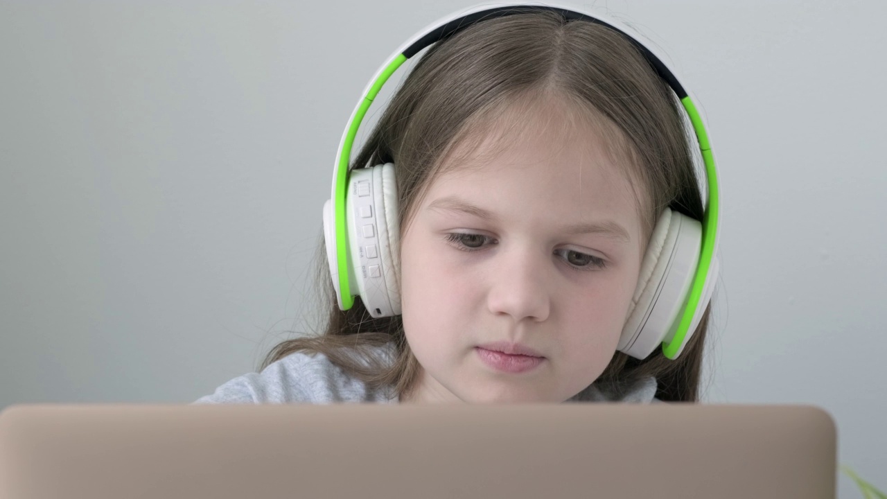 白人女学生在笔记本电脑上戴着耳机，通过互联网在线视频呼叫家教视频素材