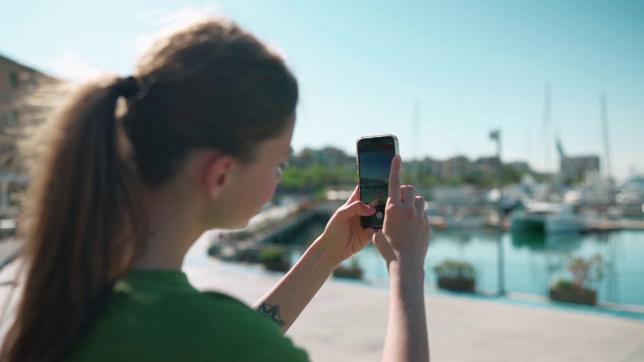 金发女人在手机上拍摄海滨照片视频素材
