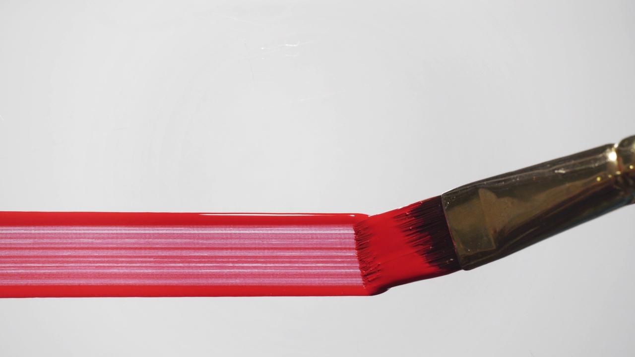 艺术家用画笔在白色背景上画红线。视频素材