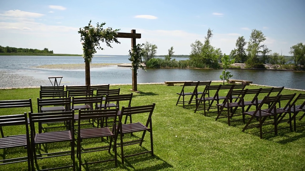 婚礼拱门和木椅的背景是美丽的河流。夏天的一天视频素材