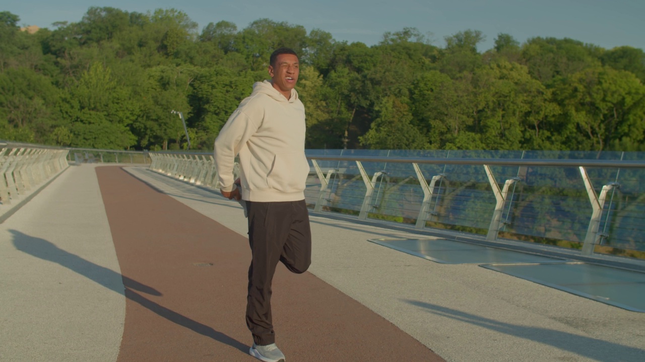 运动健康的非洲裔美国男性跑步者在户外慢跑前热身腿视频素材