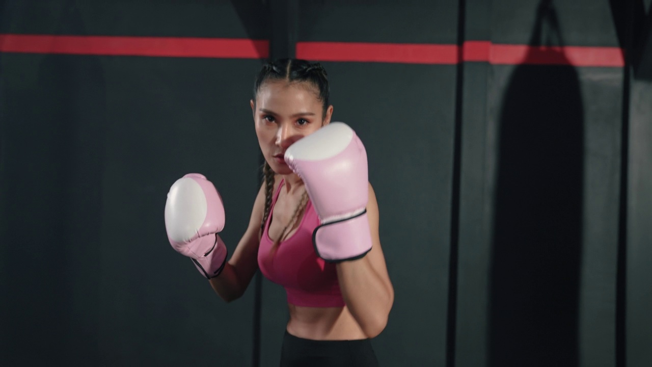 年轻的亚洲女子训练她的拳击动作。视频下载