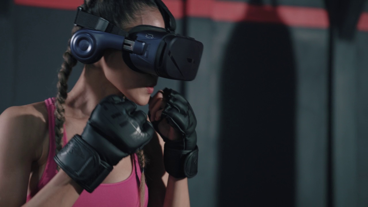 年轻的亚洲女性戴着VR头盔训练她的拳击动作。视频下载