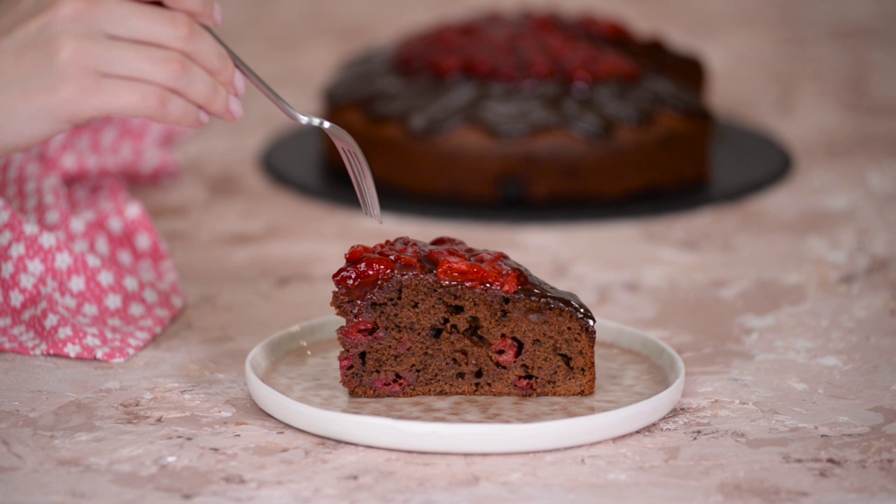 一块自制的美味樱桃巧克力蛋糕，用叉子拿一块。视频下载