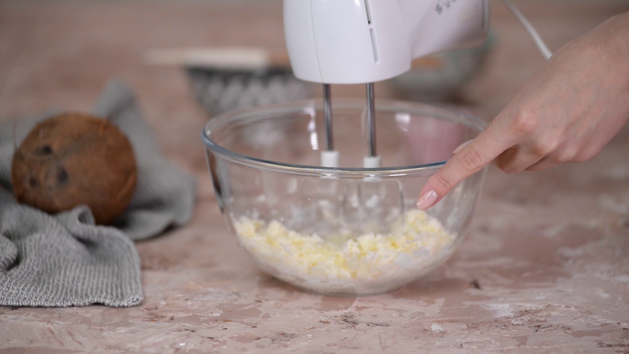 用手摇搅拌机在玻璃碗中搅拌黄油和糖。做奶油或生面团在家烘烤。视频下载