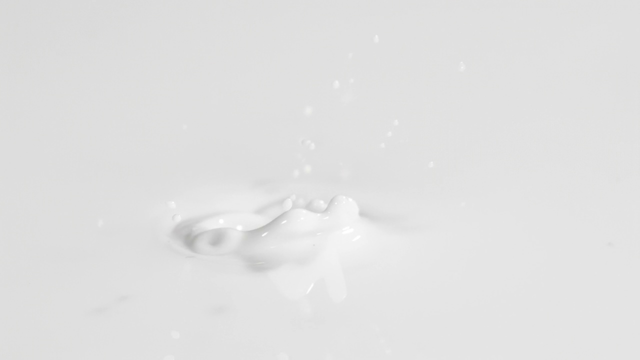 一个蓝莓飞溅到液体奶油或牛奶在4K超级慢动作视频素材