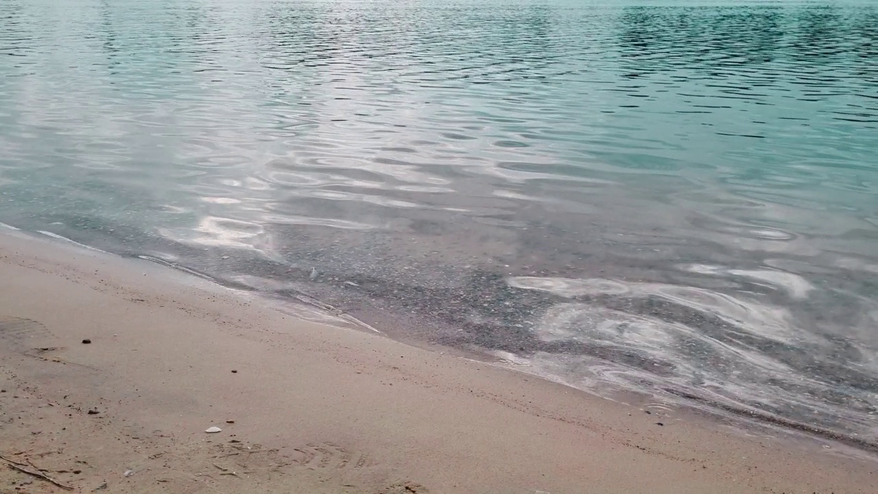 海浪拍打着海岸。沙滩和蓝色的海水。暑假概念，自然背景。视频素材