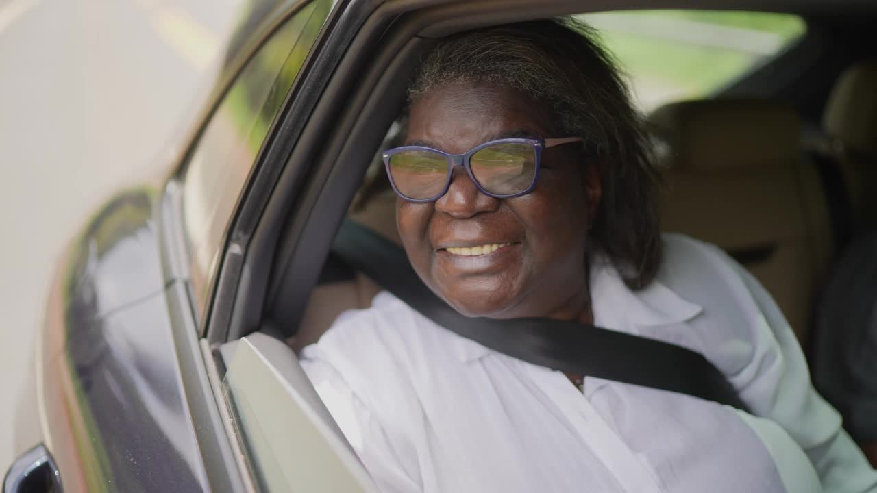 沉思的老年妇女看着风景在汽车上的公路旅行视频素材
