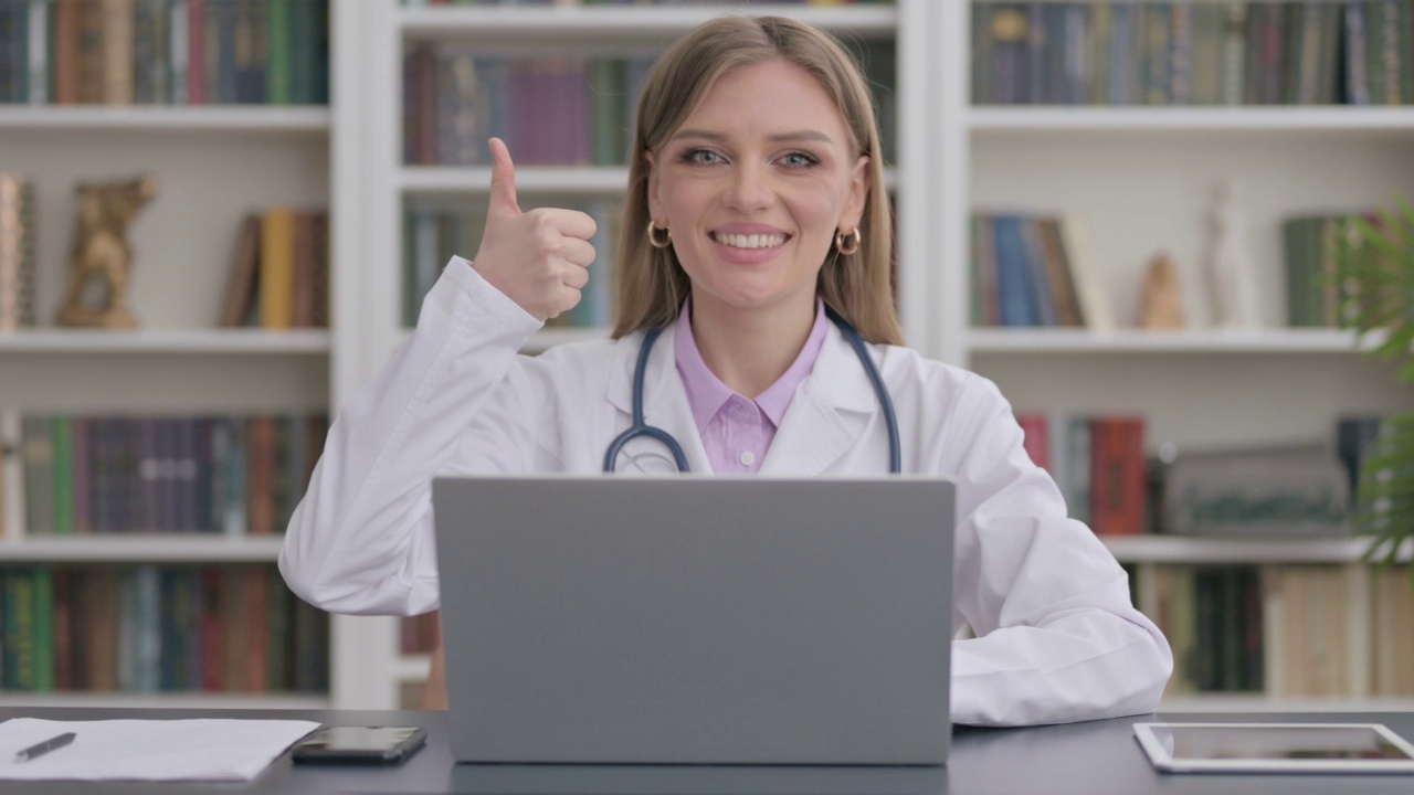 女医生在诊所使用笔记本电脑时竖起大拇指视频素材