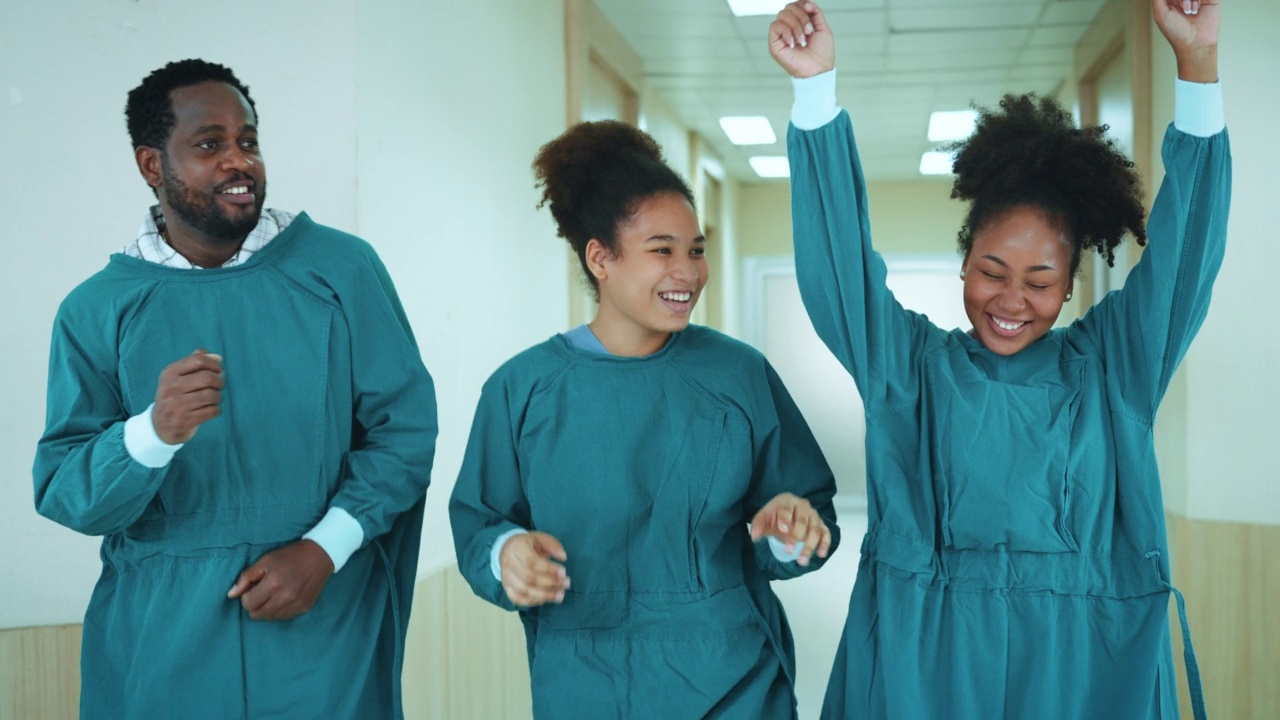 快乐的非裔美国医生、护士和助理团队在医院的走廊上跳舞。医务人员享受。视频素材