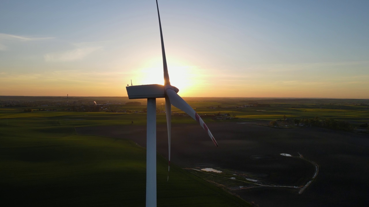 空中特写风车旋转的力量的风力和产生可再生能源的绿色生态方式在地球上的日落视频素材