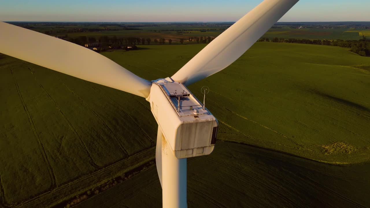 近距离观察在日落期间生产可再生自然能源的风车发电机的叶片视频素材