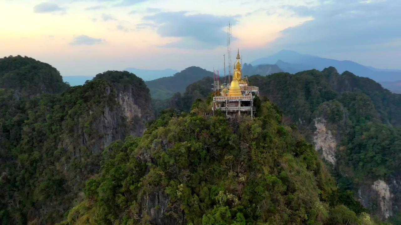 无人机拍摄的巨大的金佛雕像矗立在山顶上。泰国甲米虎洞寺。视频下载