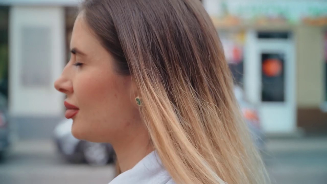 肖像年轻的阳光女子与金发走在欧洲城市的街道视频素材