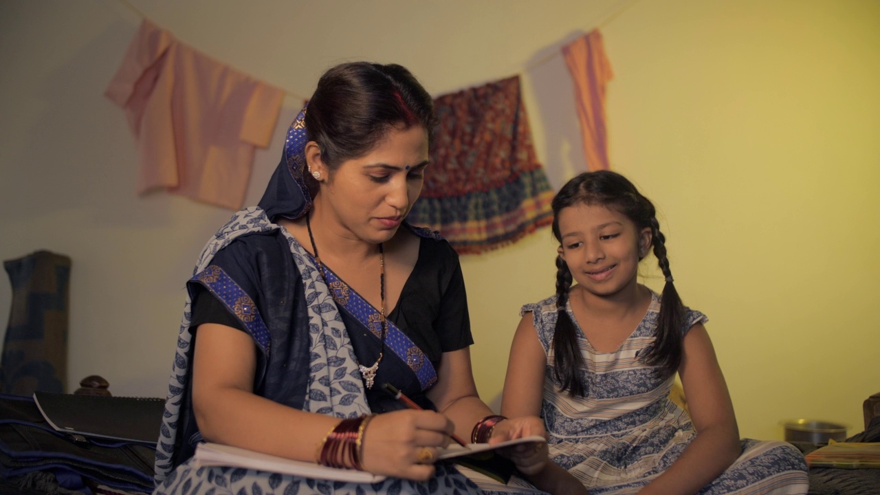 一个印度母亲在家里快乐地教她的小女儿的乡村场景视频素材